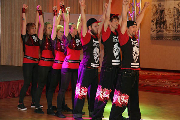 Sieben Tänzer des Tanzverein Empire of Outcast stehen hintereinander und tanzen die Rocking Empire Show