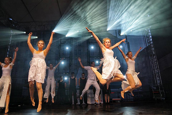 Tanzauftritt auf der Bühne des Dresdner Stadtfestes des Tanzvereins Empire of Outcast, TänzerInnen springend in weißen Kostümen